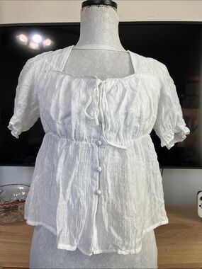 white milkmaid-style crop blouse featuring a square neckline, front tie ribbon